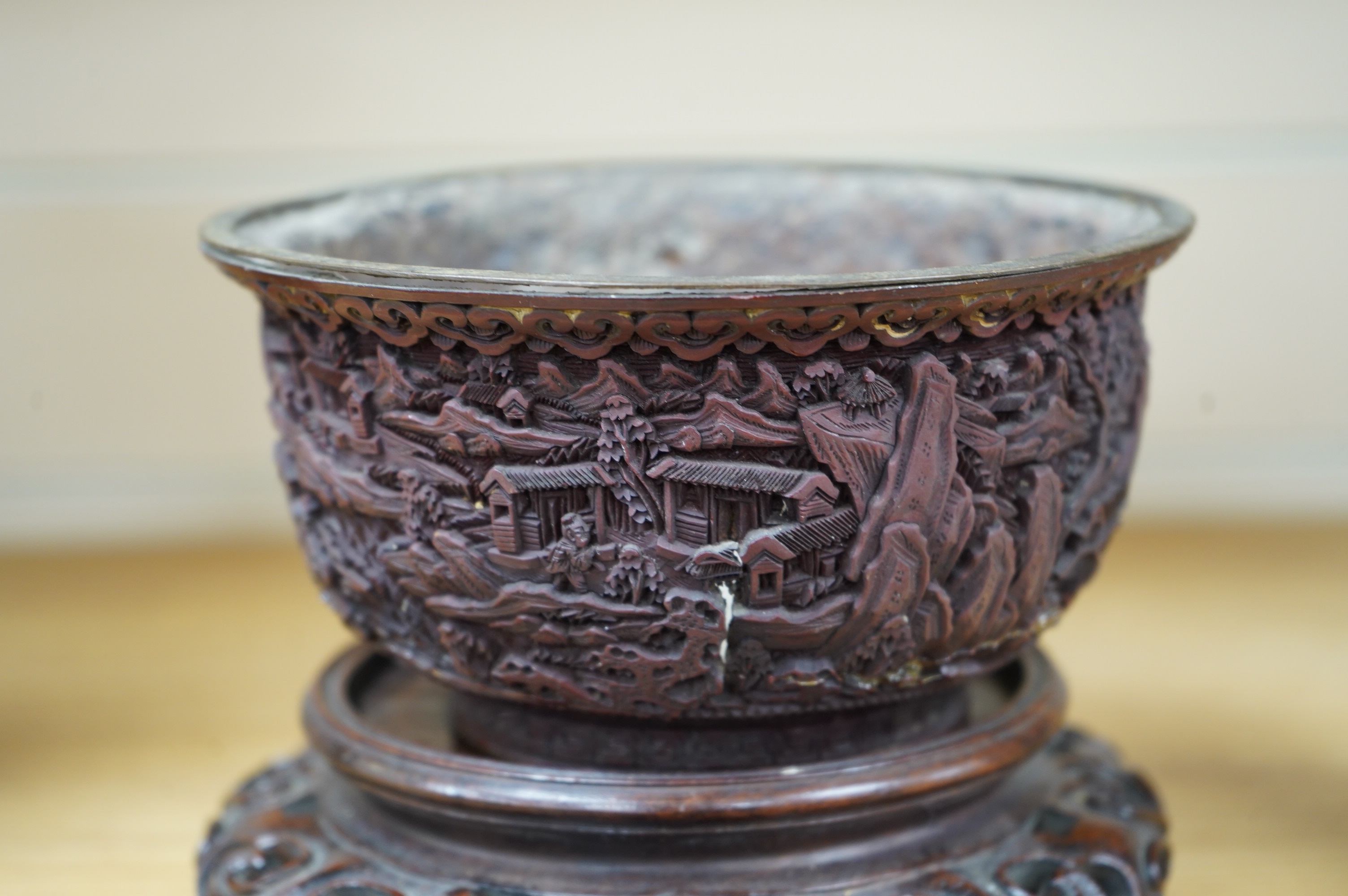 An 18th/19th century Chinese cinnabar lacquer bowl, on carved hongmu stand and a Chinese pierced brass disc. Condition - poor